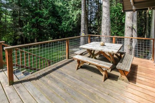 a wooden deck with a wooden table and benches at The Chalet on Lopez in Islandale