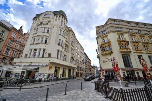 ulica z dwoma wysokimi budynkami na ulicy miejskiej w obiekcie Apartmánový Dům Centrum w mieście Brno