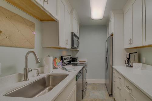 - une cuisine avec des placards blancs et un évier dans l'établissement 104 Inlet Sands Condo, à Inlet Beach