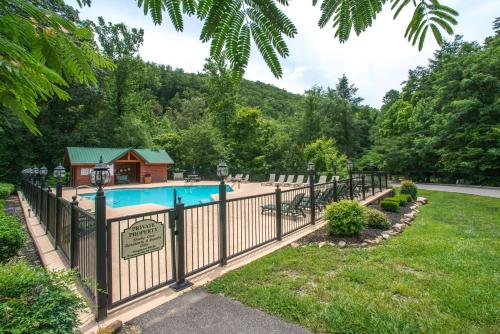 a fence around a pool with a house behind it at Mystic Falls Lodge in Waldens Creek