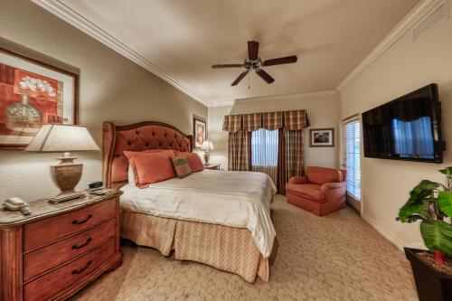 a bedroom with a bed and a television and a chair at Sunset Spectacular in Kissimmee
