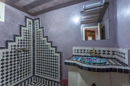 un baño con lavabo y espejo en Kasbah Tizzarouine, en Boumalne