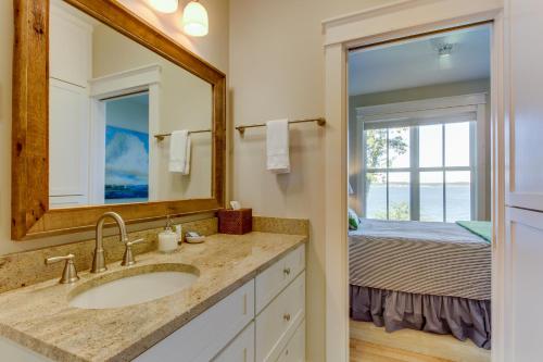 a bathroom with a sink and a mirror and a bed at Orcas Beach Cottage in Eastsound