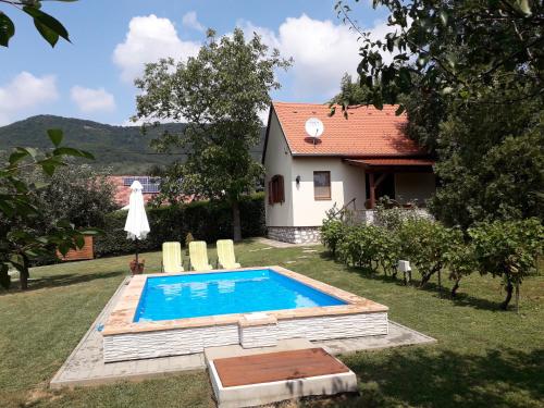una piscina en el patio de una casa en Cseresznyevirág Vendégházak, en Kővágószőlős