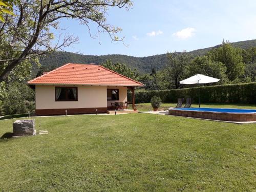 una casa con piscina en un patio en Cseresznyevirág Vendégházak, en Kővágószőlős