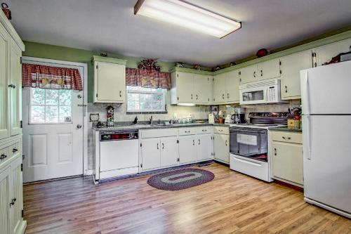 a kitchen with white appliances and a wooden floor at Bearadise in Ellijay