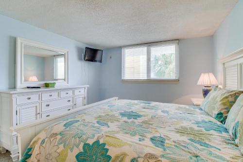1 dormitorio con cama, tocador y espejo en Dunes on the Bay, en Pensacola Beach