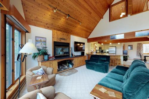 a living room with a blue couch and a tv at South Hill Lodge in Ludlow