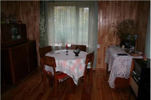 a dining room with a table and chairs and a window at Zīļulejas in Dzelzava