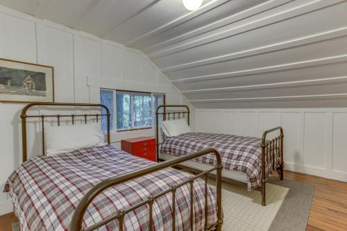 two beds in a room with white walls at Renee's Log House in McKenzie Bridge