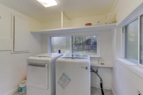 a small kitchen with a refrigerator and a window at Renee's Log House in McKenzie Bridge