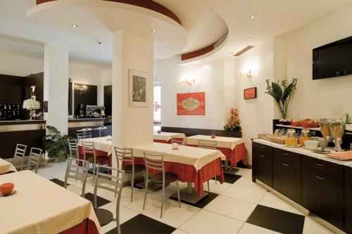 um restaurante com mesas e cadeiras num quarto em Hotel Granducato em Montelupo Fiorentino