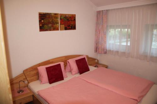 a bedroom with a bed with two pink pillows at Haus Krismer in Radstadt