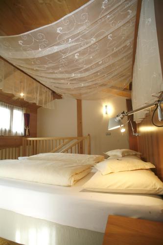 a large bed with a canopy in a room at Hotel Ortler in Ultimo
