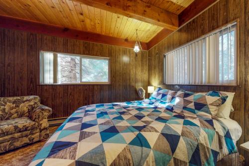 1 dormitorio con 1 cama en una habitación con paredes de madera en Pond View Lodge en Shaver Lake