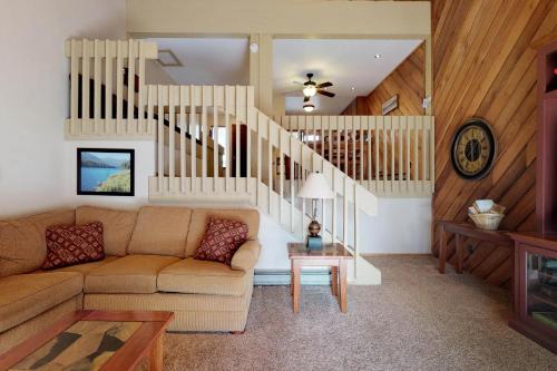 a living room with a couch and a staircase at Blue Jay Condominium in Lakeshore