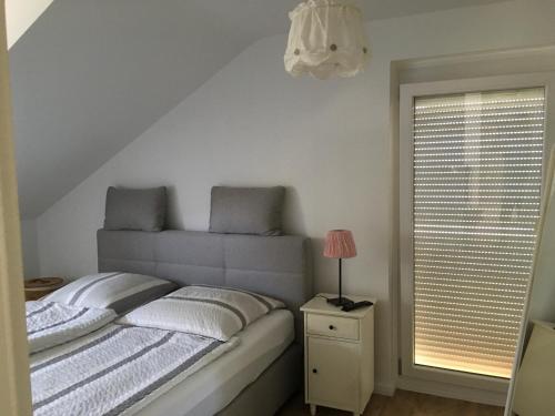 ein Schlafzimmer mit einem Bett mit einer Lampe und einem Fenster in der Unterkunft Ferienhaus Sonnenblume in Hameln