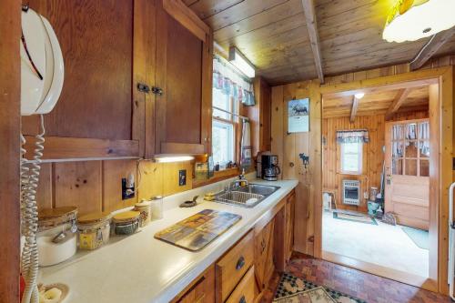 - une cuisine avec des placards en bois et un évier dans l'établissement Split Rock Cottage, à Kokadjo