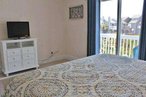 a bedroom with a bed and a tv and a window at Barrier Dunes Hideaway in Oak Grove