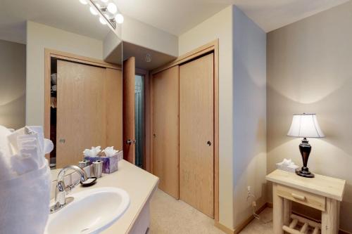 La salle de bains est pourvue d'un lavabo et d'une lampe sur une table. dans l'établissement Watch Hill, à Silverthorne