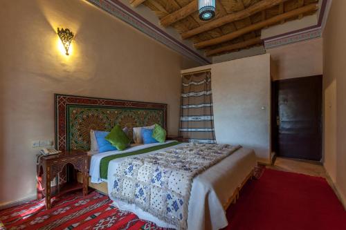 un dormitorio con una cama grande en una habitación en Kasbah Tizzarouine, en Boumalne