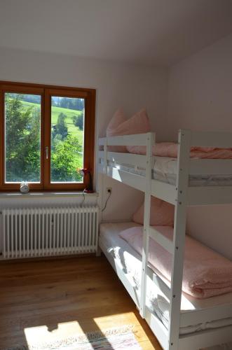 a bedroom with two bunk beds and a window at Ferienhaus Mätzler in Schwarzenberg