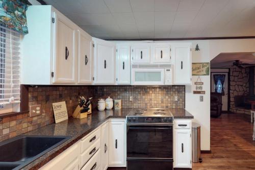 a kitchen with white cabinets and a black oven at Plain Getaway in Chumstick