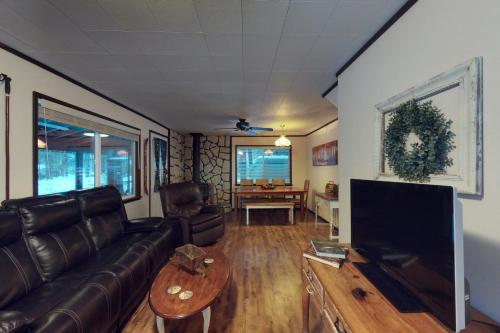 a living room with a couch and a flat screen tv at Plain Getaway in Chumstick