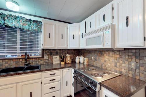 a kitchen with white cabinets and a sink and a stove at Plain Getaway in Chumstick