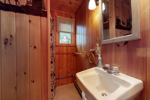 uma casa de banho com um lavatório branco e um espelho. em Water's Edge em The Highlands