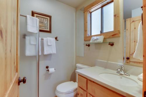 a bathroom with a toilet and a sink and a window at 13 Deer Lane in Sunriver