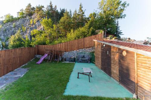 a backyard with a playground with a wooden fence at Pension Fialka in Český Krumlov