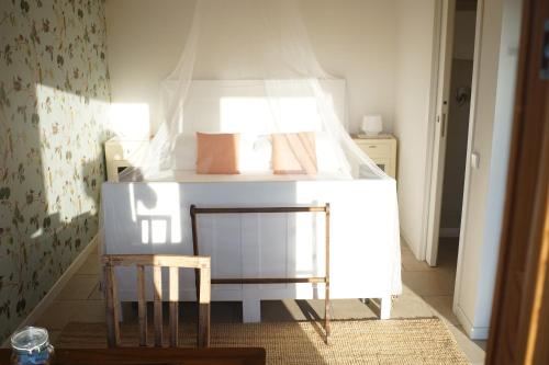 um pequeno quarto com uma cama e uma cadeira em Agriturismo Fattoria Togonegro em Marostica