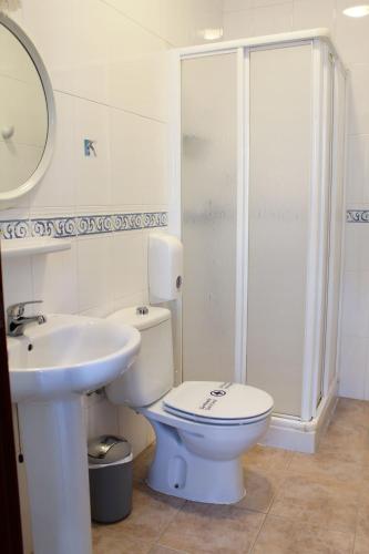 a bathroom with a toilet and a sink and a shower at Pensión Guerrero in Cabra