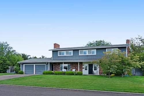 a large house with a driveway and grass at Highland Park House in Walla Walla