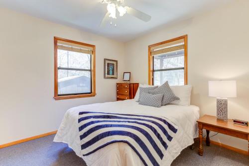 a bedroom with a bed and a table and two windows at Moss Creek Cabin in Morganton
