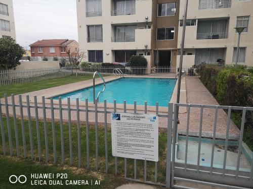 a fence with a sign in front of a swimming pool at Relajado y central in Rancagua