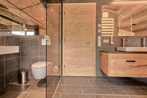 a bathroom with a shower and a toilet and a sink at Chalets - The Peak in Sölden