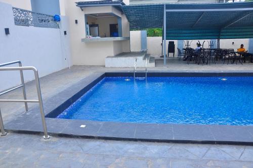 a large blue swimming pool next to a building at Lit Suites in Abuja