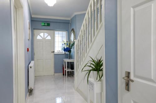 a hallway with blue walls and a white door at Amazing London in London