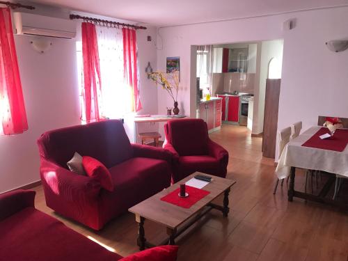 ein Wohnzimmer mit zwei roten Sofas und einem Tisch in der Unterkunft Apartment in family house Linda in Čavle