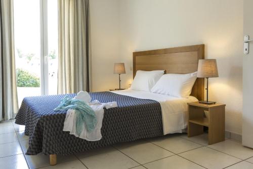 Habitación de hotel con cama y ventana en Résidence Odalys Horizon Morgat en Crozon