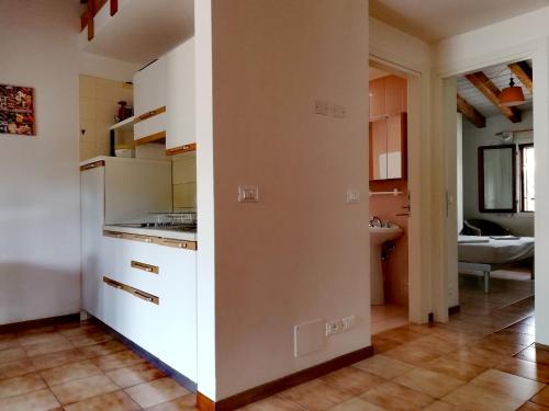 eine Küche mit weißen Schränken und einem Fliesenboden in der Unterkunft Signora Ruth - Aprilia Residence in Aprilia Marittima