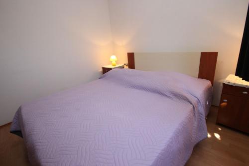 sypialnia z fioletowym łóżkiem i szafką nocną w obiekcie Apartments Saša - pets friendly! w Poreču