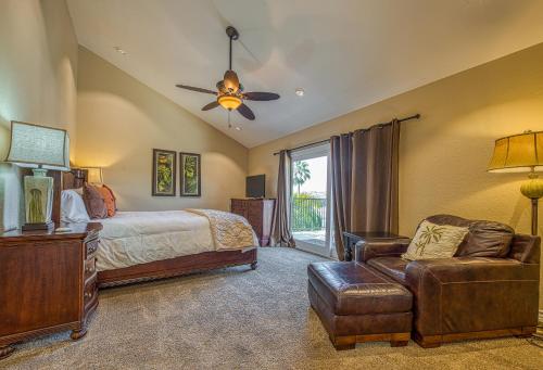 a bedroom with a bed and a couch and a fan at North Beach B in San Clemente