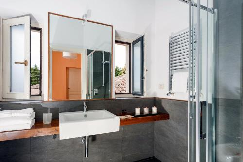 een badkamer met een wastafel en een spiegel bij Wine Resort Villagrande in Milo