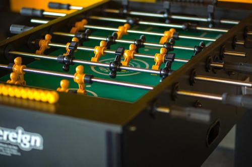 a row of green foosball tables sitting next to each other at Hivetel in Chalong 