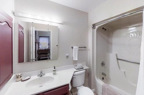 ein Badezimmer mit einem Waschbecken, einem WC und einem Spiegel in der Unterkunft Aspenwood 4262 in Pagosa Springs