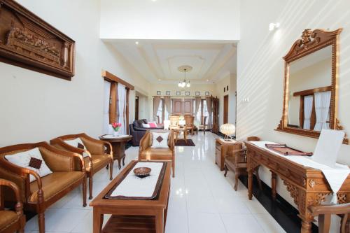 a living room filled with furniture and a mirror at Nginap at Joy House in Sleman