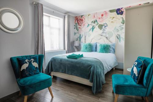 a bedroom with a bed and two blue chairs at Amazing London in London